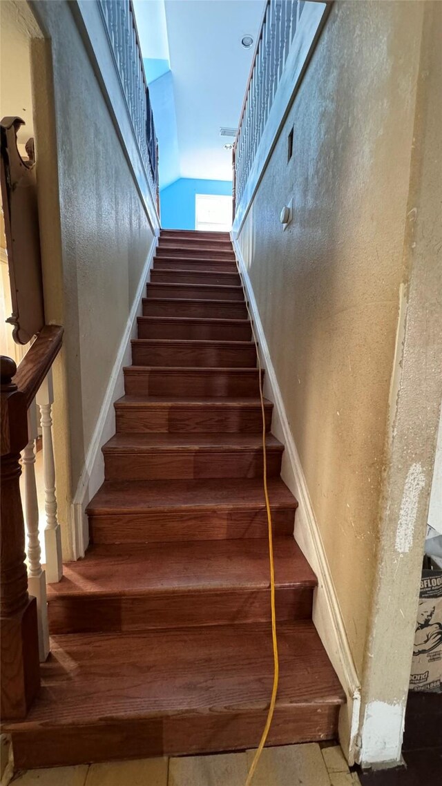 staircase with hardwood / wood-style floors