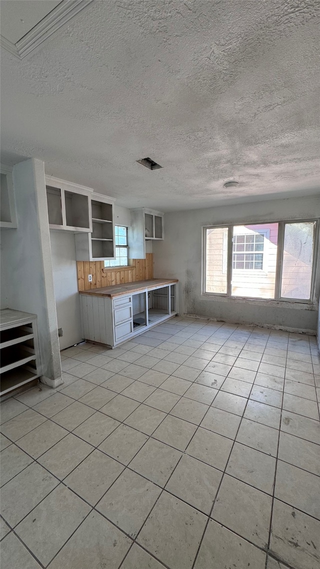 interior space featuring light tile patterned flooring and a textured ceiling