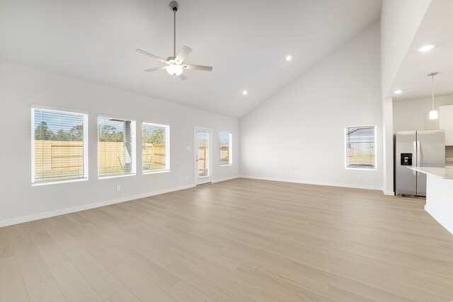 unfurnished living room featuring ceiling fan, light hardwood / wood-style flooring, and high vaulted ceiling