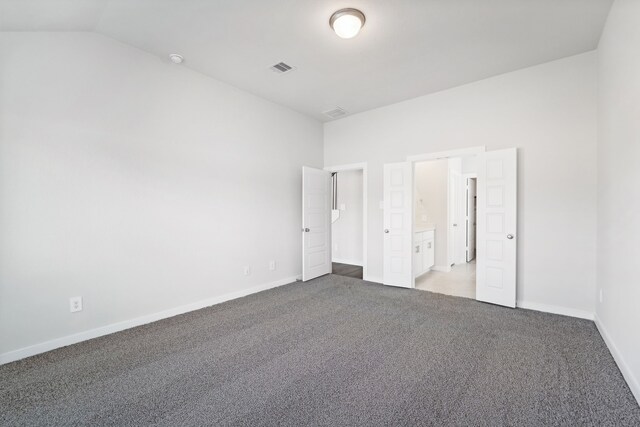 unfurnished bedroom with carpet and vaulted ceiling