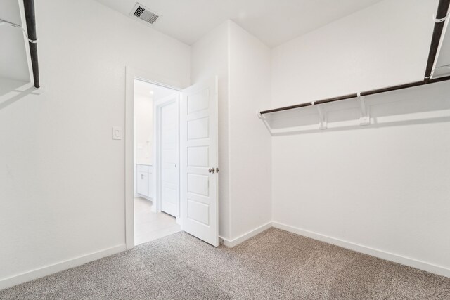 walk in closet featuring light colored carpet