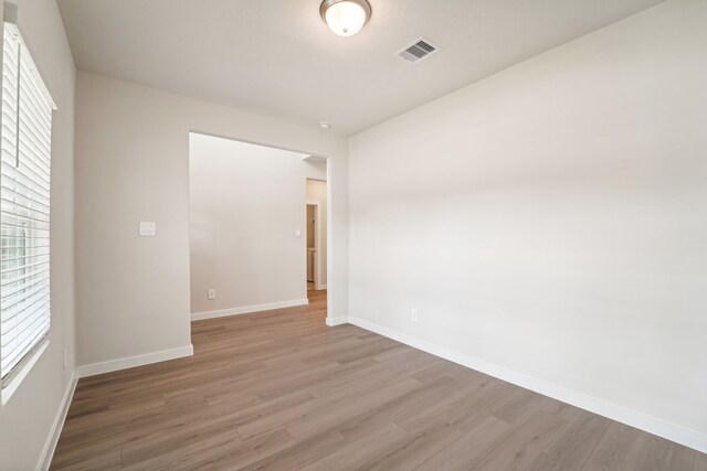 empty room with light hardwood / wood-style floors and a wealth of natural light