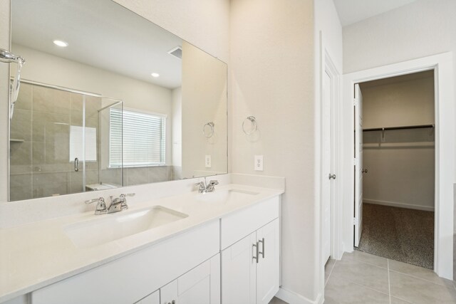 bathroom with tile patterned flooring, vanity, and walk in shower