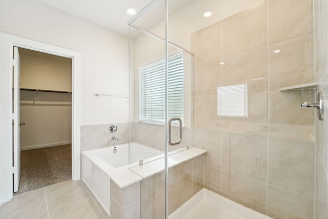 bathroom with tile patterned flooring and separate shower and tub