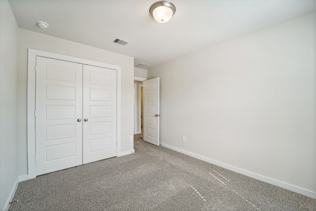 unfurnished bedroom featuring carpet floors and a closet