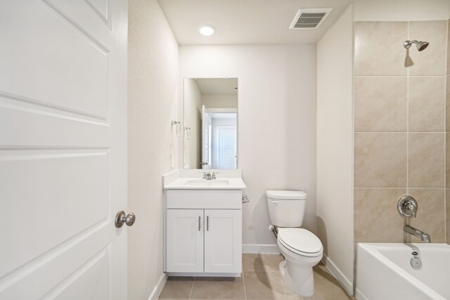 full bathroom featuring toilet, vanity, tile patterned floors, and tiled shower / bath