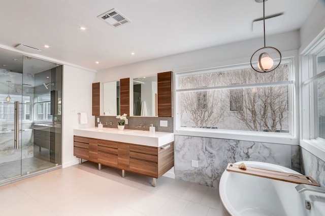 bathroom featuring vanity, a shower with shower door, and decorative backsplash