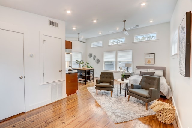 living area with ceiling fan and light hardwood / wood-style flooring