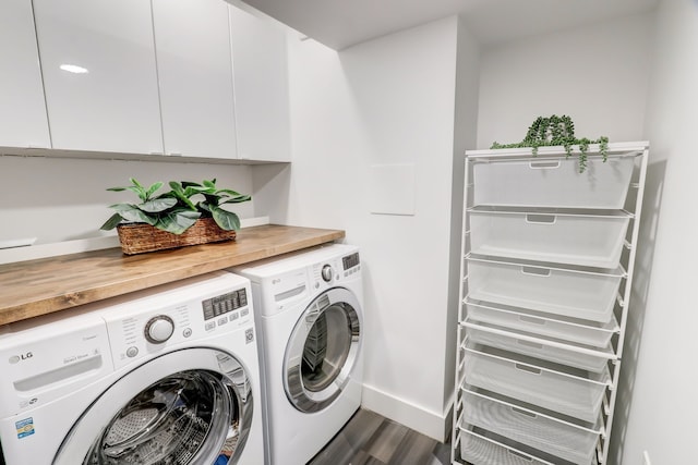 washroom featuring cabinets, dark hardwood / wood-style floors, and washer and clothes dryer