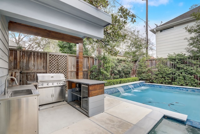 view of pool with pool water feature, area for grilling, exterior kitchen, and sink