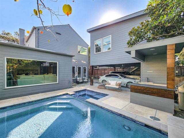 view of pool with an in ground hot tub, a patio area, and a fire pit