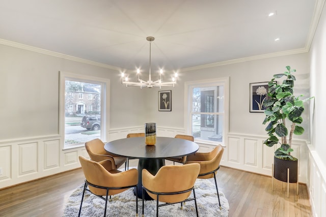 dining room with crown molding, a notable chandelier, and light wood-type flooring