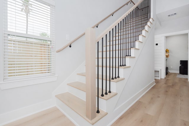 stairs featuring hardwood / wood-style flooring and plenty of natural light