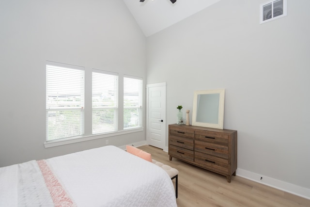 bedroom with ceiling fan, light hardwood / wood-style floors, and high vaulted ceiling