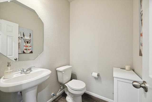 bathroom featuring toilet, sink, and hardwood / wood-style flooring