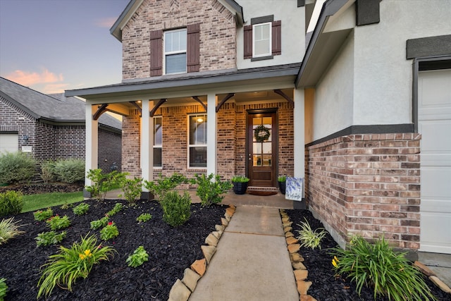 exterior entry at dusk featuring covered porch