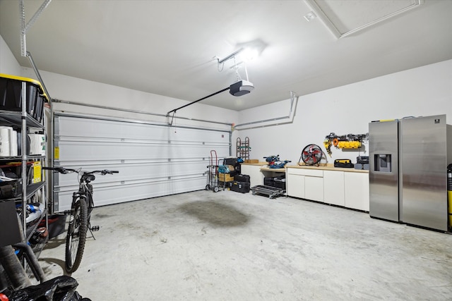 garage featuring a garage door opener and stainless steel fridge