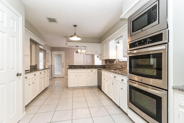 488 Stephen F Austin Dr, Conroe, TX 77302 - kitchen with stainless steel appliances, a peninsula, a sink, decorative backsplash, and healthy amount of natural light
