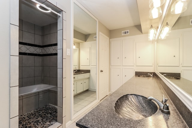 bathroom with vanity, tile patterned flooring, and tiled shower