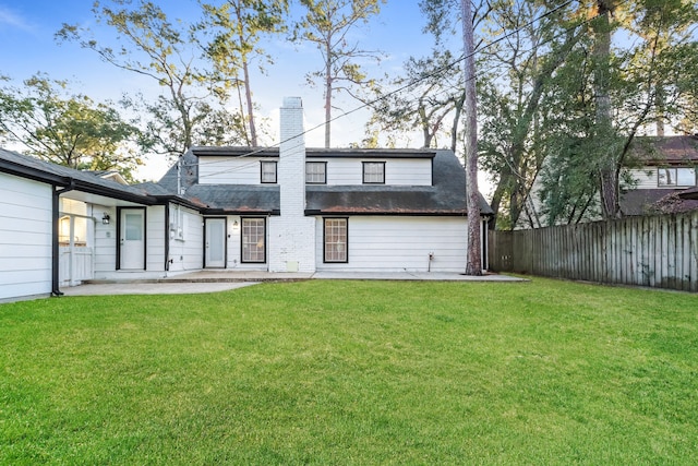 rear view of property with a lawn and a patio