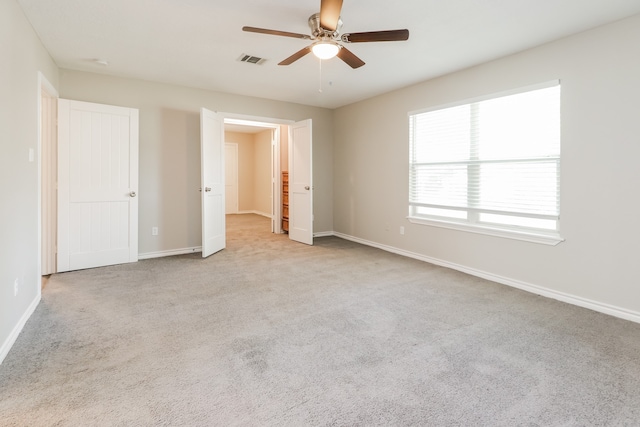 carpeted spare room with ceiling fan