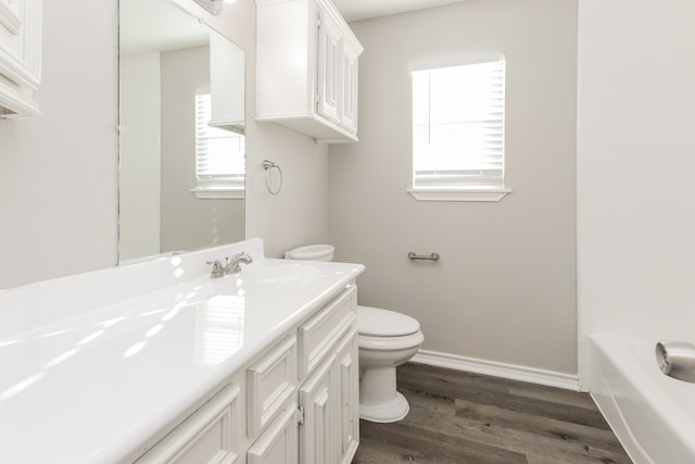 bathroom with toilet, vanity, and hardwood / wood-style floors