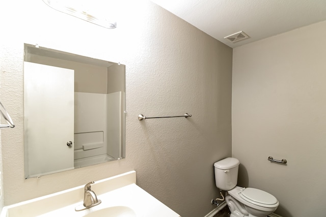 bathroom featuring a textured ceiling, sink, and toilet