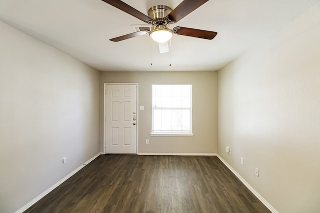 spare room featuring dark wood-type flooring and ceiling fan