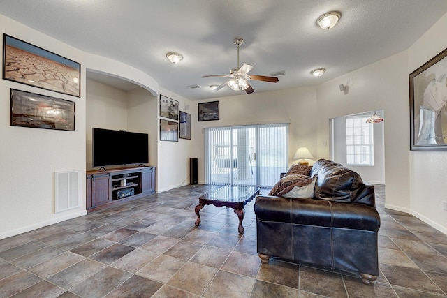 3215 County Road 160, Alvin, TX 77511 - living area featuring a ceiling fan, dark stone finish floors, baseboards, and arched walkways