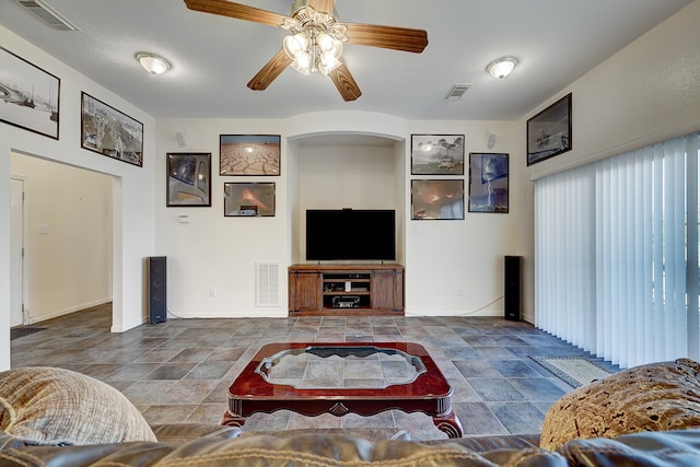 living room featuring a textured ceiling and ceiling fan