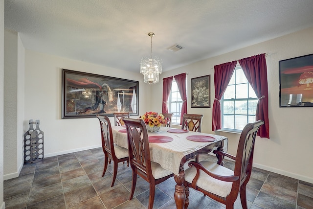 dining room featuring a textured ceiling and an inviting chandelier