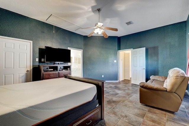 3215 County Road 160, Alvin, TX 77511 - bedroom with attic access, a textured wall, ceiling fan, connected bathroom, and stone finish floors