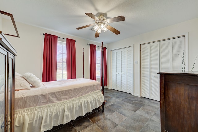 bedroom with ceiling fan, a textured ceiling, and multiple closets