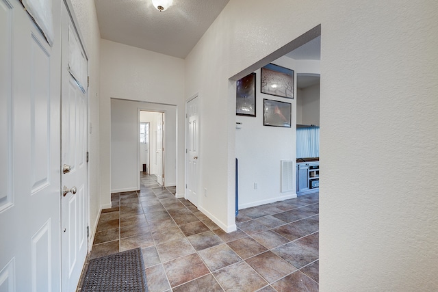 hall with a textured ceiling