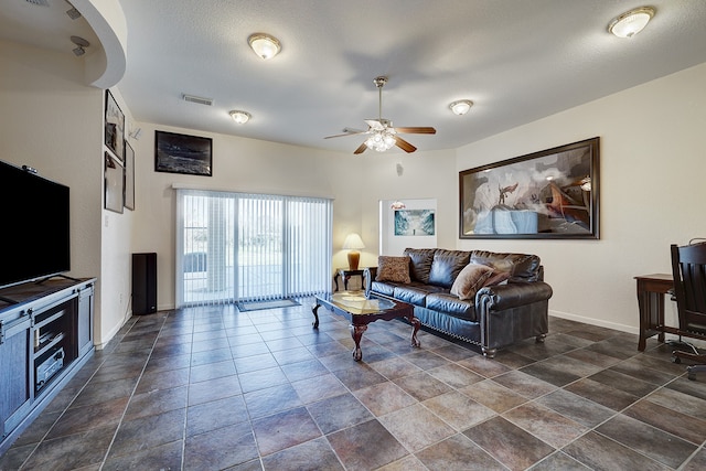 living room featuring a textured ceiling and ceiling fan