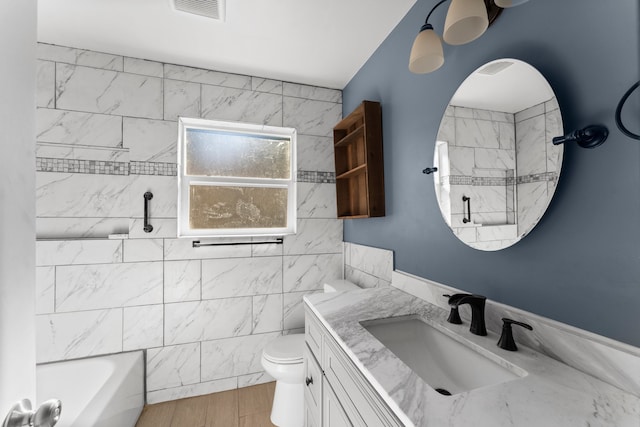 full bathroom with wood-type flooring, vanity, toilet, and tiled shower / bath combo