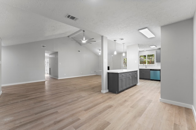 unfurnished living room with lofted ceiling with beams, ceiling fan, a textured ceiling, and light hardwood / wood-style flooring