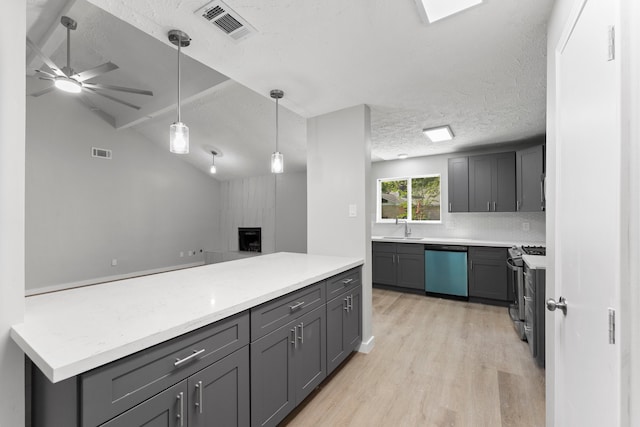 kitchen with vaulted ceiling, gray cabinets, a textured ceiling, light hardwood / wood-style floors, and stainless steel appliances