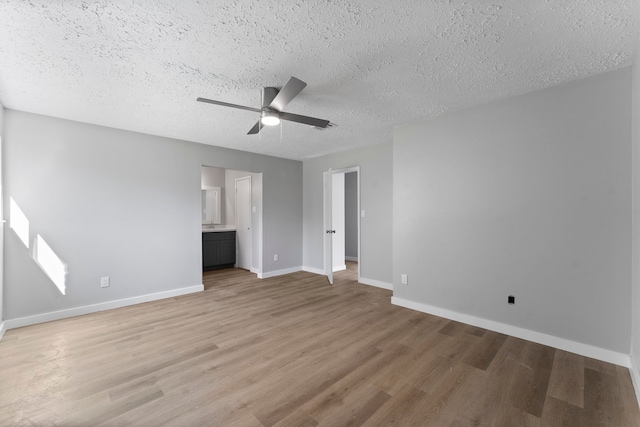 unfurnished bedroom with connected bathroom, ceiling fan, a textured ceiling, and light wood-type flooring