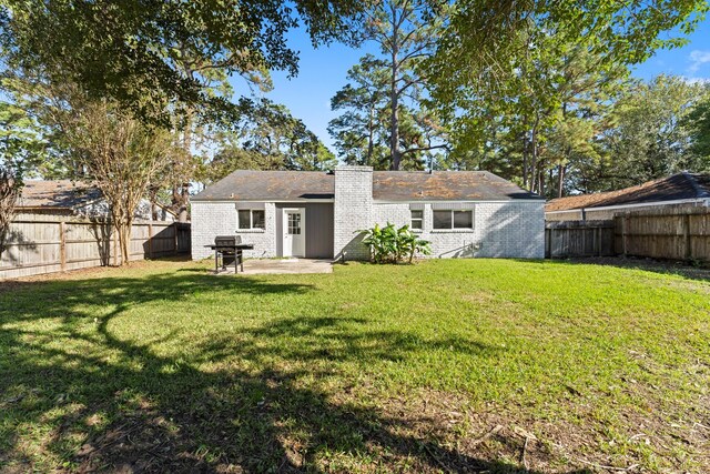 back of property featuring a patio area and a lawn