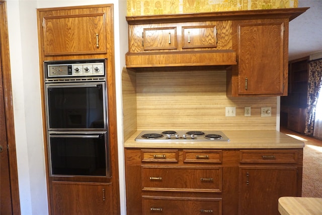 kitchen with tasteful backsplash, stainless steel gas cooktop, and double oven