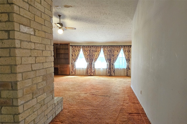 interior space featuring ceiling fan, carpet, and a textured ceiling