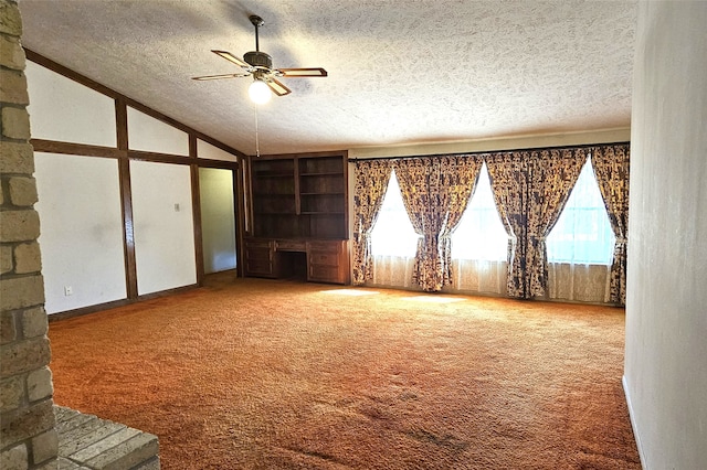 carpeted empty room featuring a textured ceiling, ceiling fan, and lofted ceiling