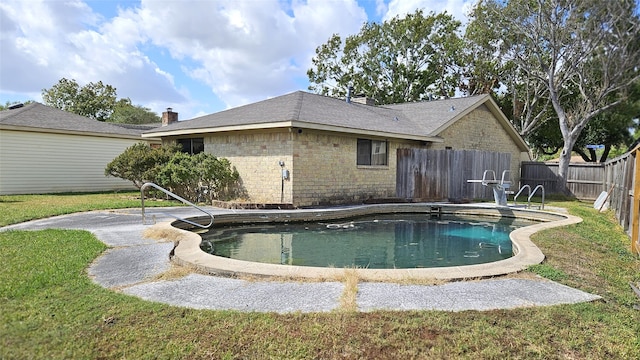 view of swimming pool with a yard