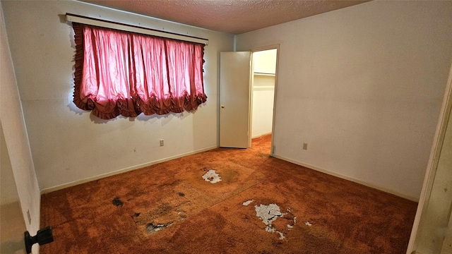 carpeted empty room with a textured ceiling