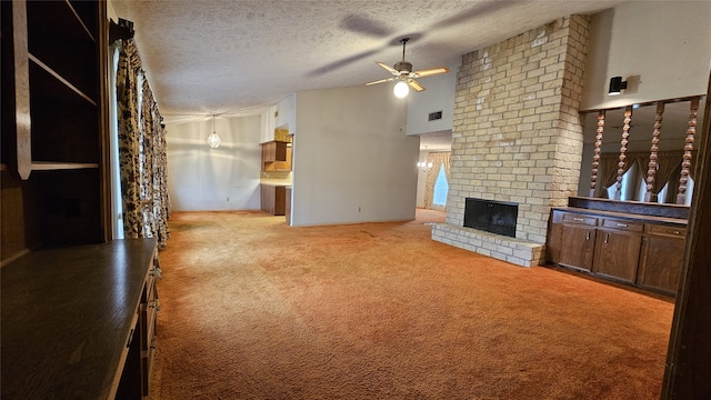 unfurnished living room featuring ceiling fan, a fireplace, light colored carpet, and a textured ceiling