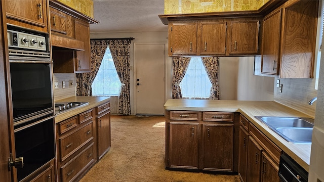 kitchen with kitchen peninsula, light carpet, a textured ceiling, black appliances, and sink