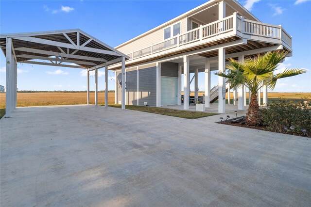 1286 Lagoon Dr, Crystal Beach, TX 77650 - view of front facade featuring concrete driveway, a carport, a deck, and stairway