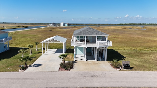 beach home featuring a front yard and a carport