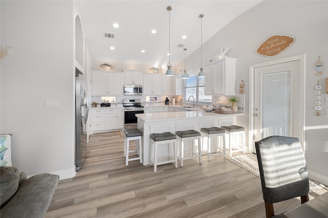 kitchen featuring stainless steel appliances, white cabinets, tasteful backsplash, high vaulted ceiling, and a breakfast bar